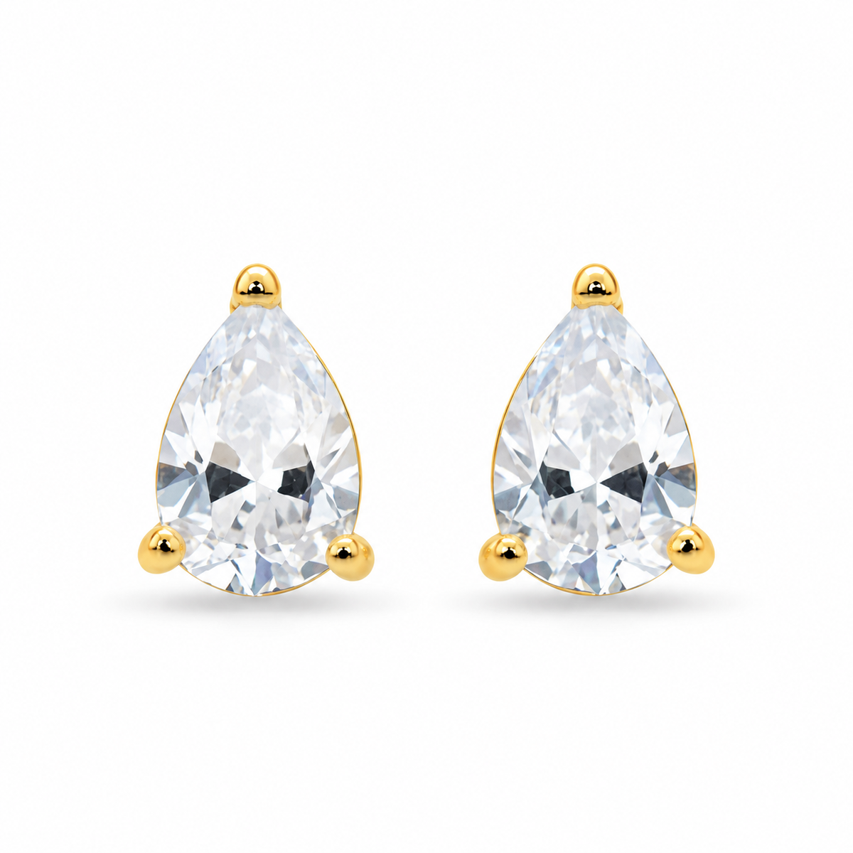 Aretes de oro amarillo 10K con piedra en forma de lágrima sobre fondo blanco